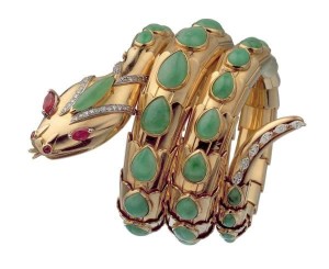 "Snake" bracelet in gold with jade, rubies and diamonds, 1968. The bracelet is designed as a coiled snake, in 18kt yellow gold, weighing gr. 126.28, set with the following gemstones: the head is set with: 46 circular diamonds, eight-eight cut, average estimated weight 0.01 ct., total approximate weight circa 0.46 ct.; 2 circular cabochon rubies, estimated weight 0.10 ct. each, total approximate weight circa 0.20 ct.; 2 marquise-shaped rubies, mixed cut, estimated weight 0.40 ct. each, total approximate weight circa 0.80 ct; 1 marquise-shaped cabochon jadeite, estimated weight circa 1.20 ct.; the coils of the serpent are set with : 43 pear-shaped cabochon jadeites of differing weights, the smallest of 0.20 ct. the largest of 1.75 ct., total approximate estimated weight 44.00 ct; the tail is set with: 6 marquise-shaped diamonds of modified brilliant-cut, estimated average weight 0.05 ct. each, total approximate weight 0.30 ct. Marks: on the reverse of the tail: "BVLGARI" engraved; on the reverse of the head: oval (illegible), "750".