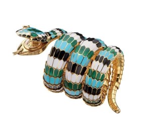 "Snake" bracelet-watch in gold with polychrome enamel and emeralds, 1967. The flexible bracelet designed as a coiled snake, the scales decorated with white, black, green and turquoise enamel, the head with pear-shaped emerald eyes concealing a gold case, champagne coloured dial; applied gold baton-shaped indexes with black profiles, at 12 paired baton-shaped indexes; "JAEGERLECOULTRE / BVLGARI / SWISS MADE" logos printed in black; black sword-shaped hands; gold back-case with asymmetrical soleil finish secured by two screws; crown winder; hand-wound mechanical movement. Marks: on the reverse of the head: "BVLGARI" engraved; on the back-case: numbered "1122607".